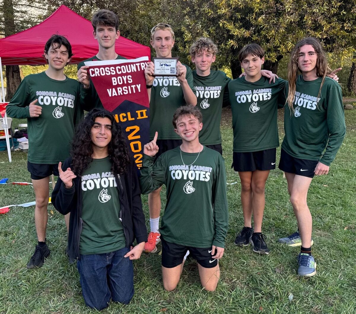 Varsity cross-country boys team posing with banner