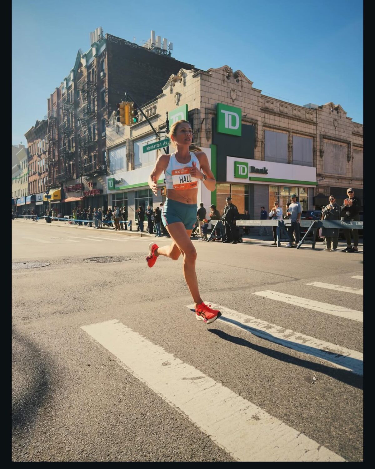 Woman runner leaping across city crosswalk