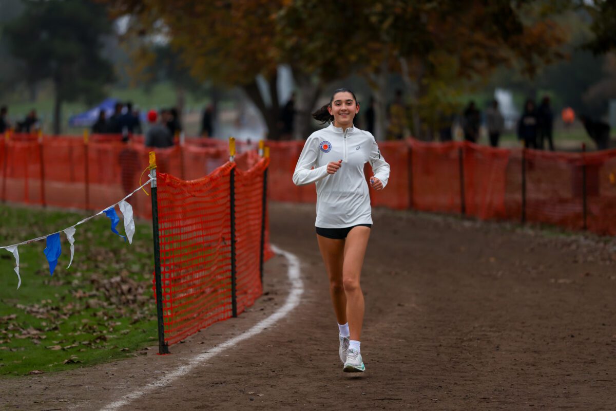 Female runner smiling on cross-country trail