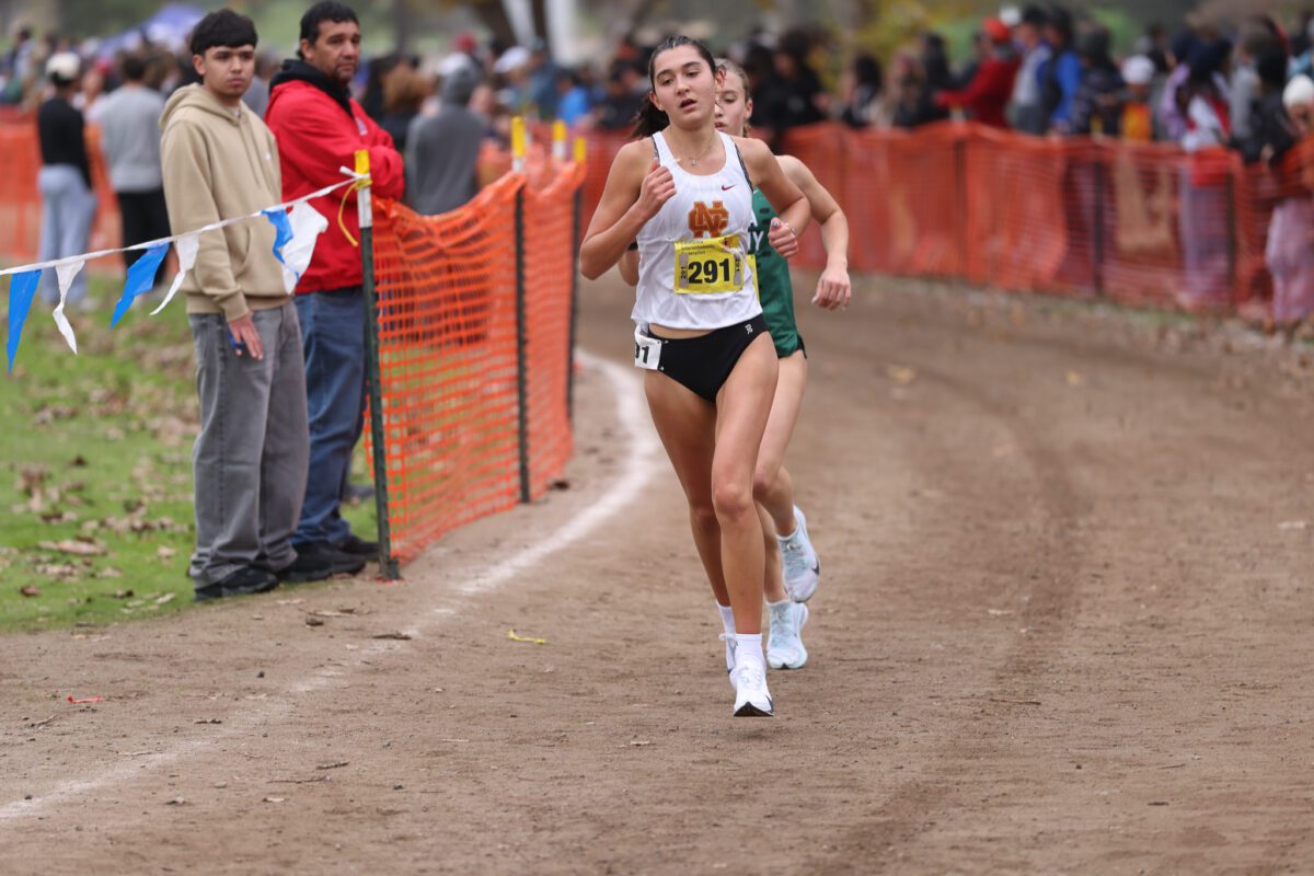 Cross-country runner leading on dirt course