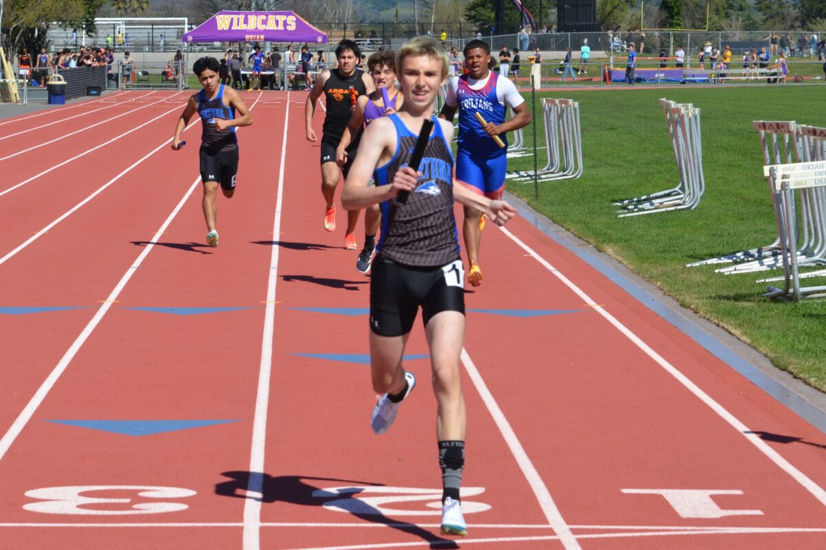High school relay runner leading on track