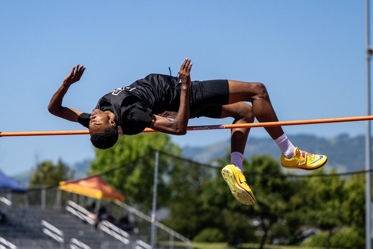 High jumper arching over bar outdoors