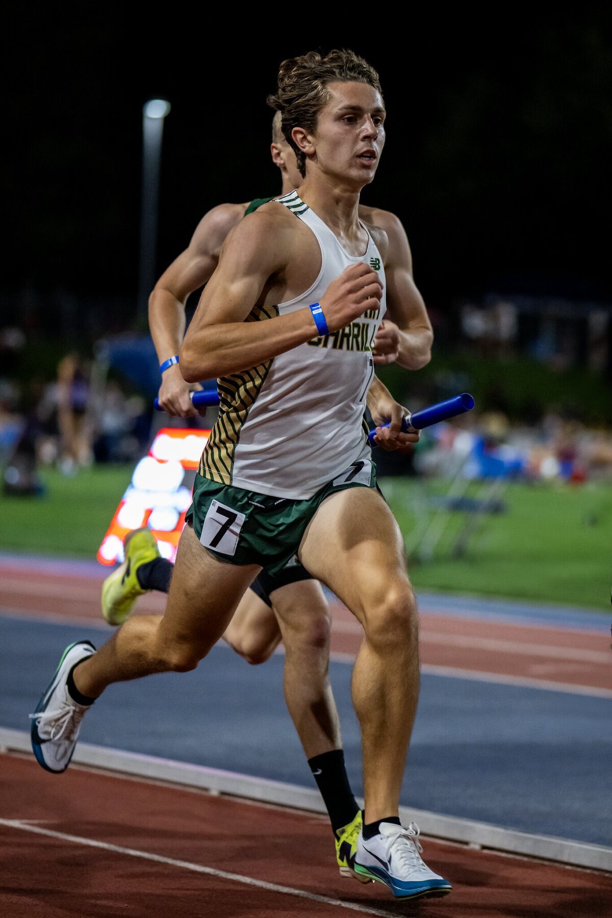 Relay runner sprinting with baton on track