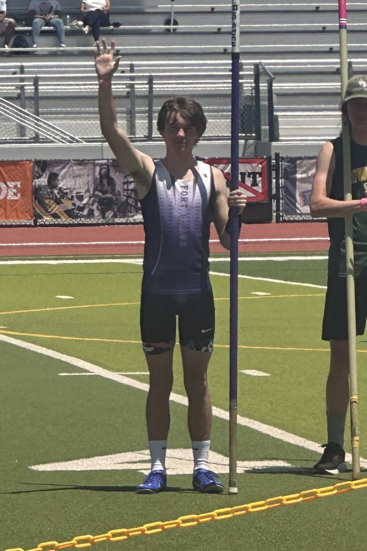 Pole vaulter waving on track field